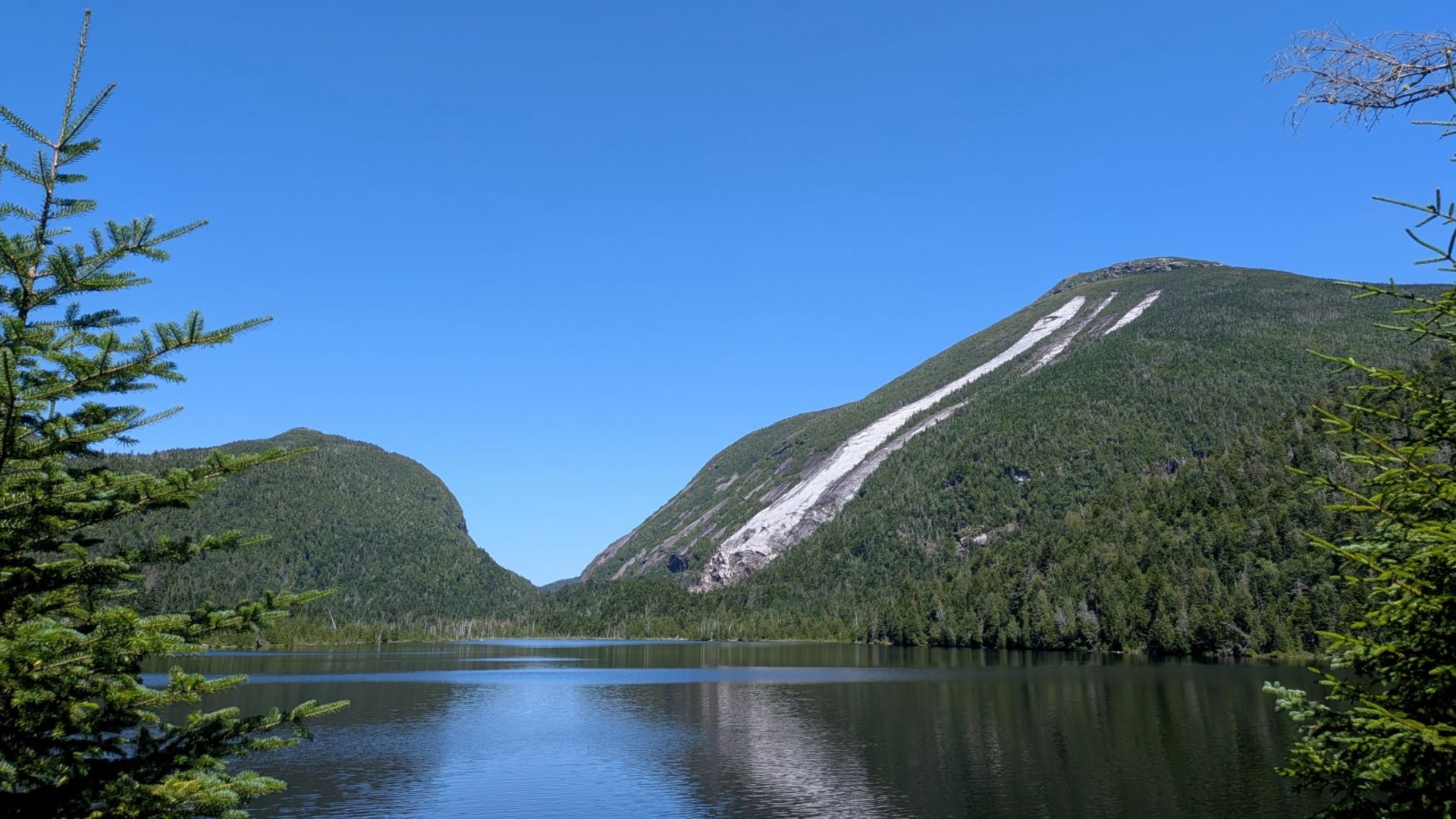 Lake Colden on a clear Summer day reflecting the mountains and deep blue sky.